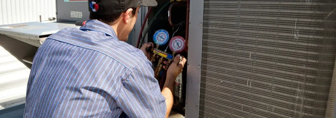 HVAC technician servicing a condenser unit in Madison