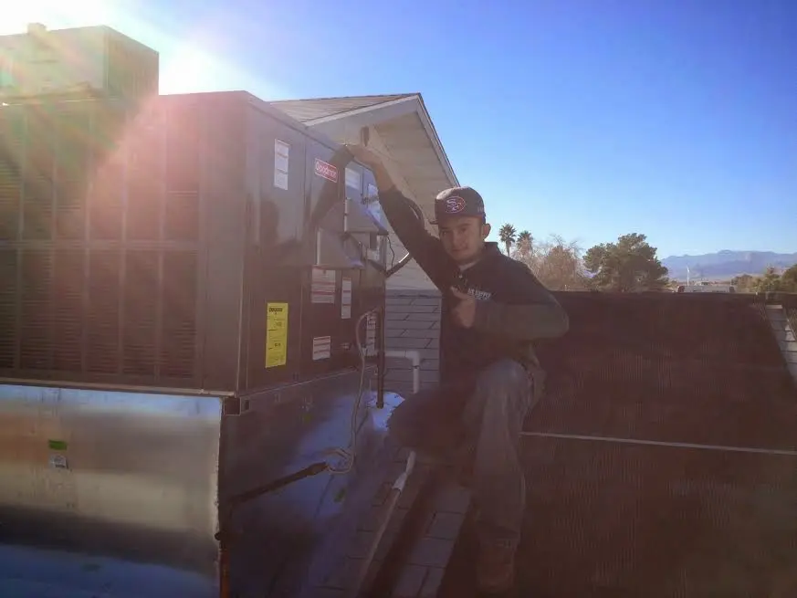 HVAC technician performing AC Tune-Up on a rooftop unit in Madison
